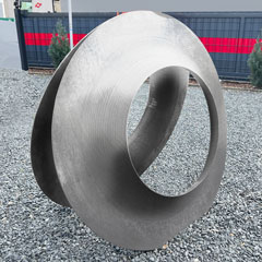Two human-sized cover disks stand back to back on dark gravel. In the background, a grey fence can be seen with a red hand-width stripe running across its entire width.